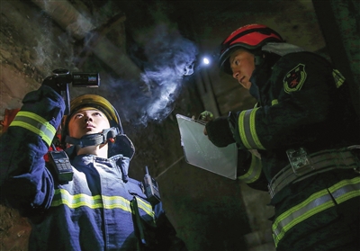 刘耀宗（左）和战友勘察记录火场及周边情况。