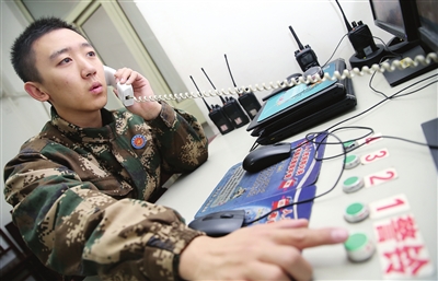 值班期间，刘耀宗一手接听电话，一手准备着随时触发警铃，争分夺秒。