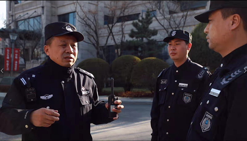 李华瑞(左一)在向小区保安介绍当前的治安情况