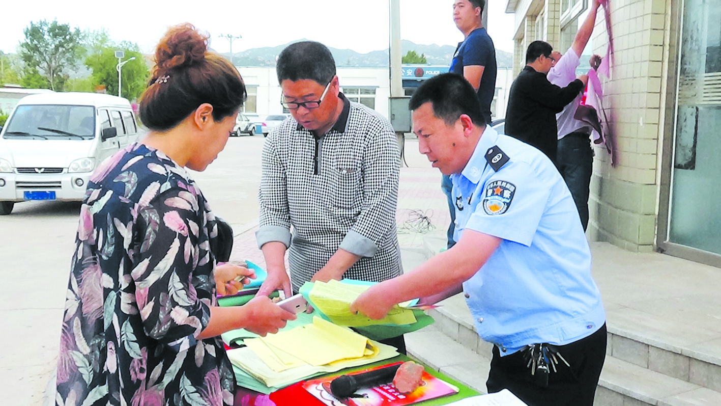 配文1：崔百仲（右一）下村屯开展法治宣传