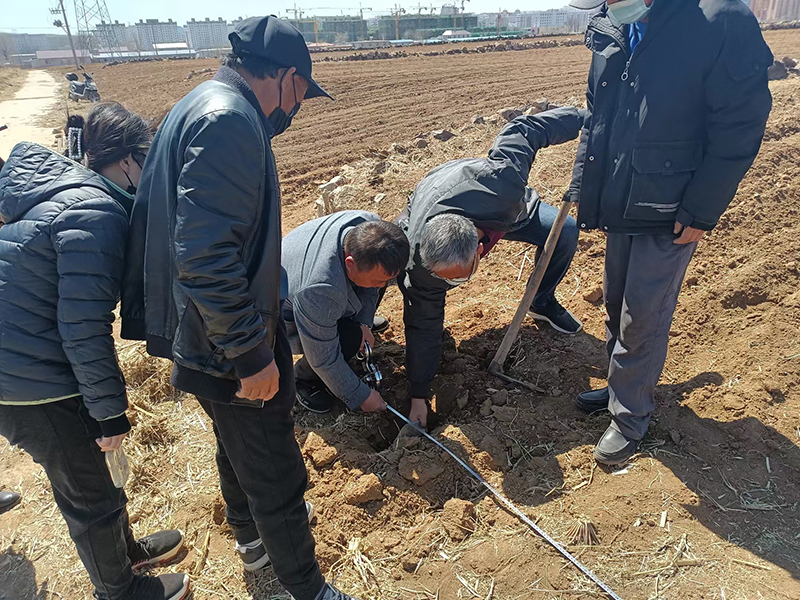 张玉峰(右二)现场调解土地纠纷