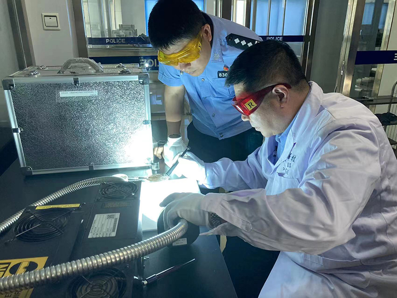 丁友(左)与同事在实验室对现场提取的指纹进行反复比对