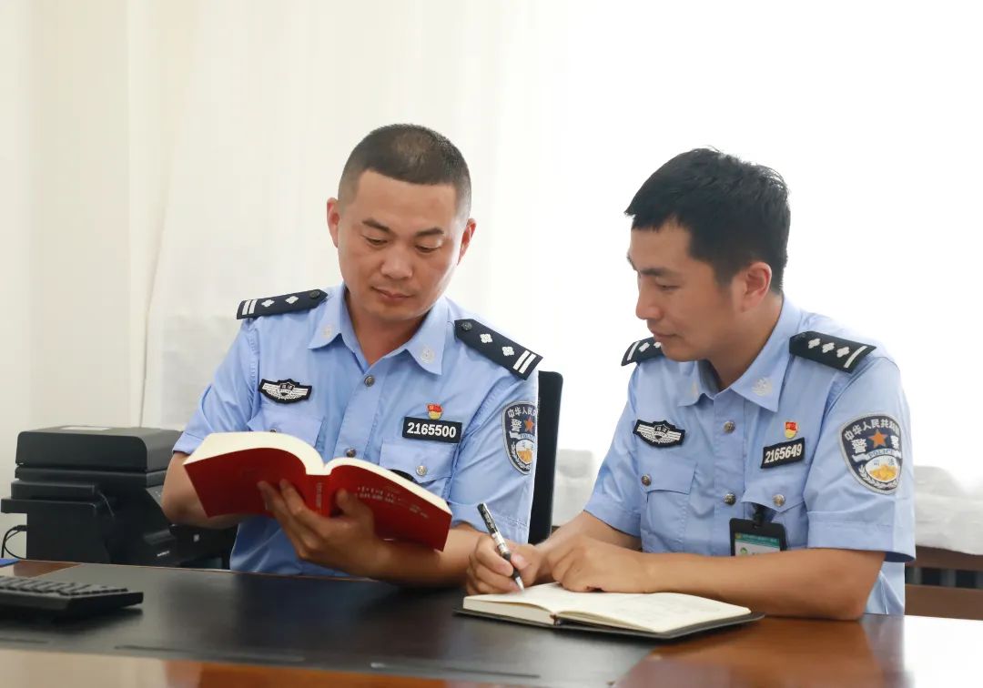 邢少华（左）与青年民警一起学习
