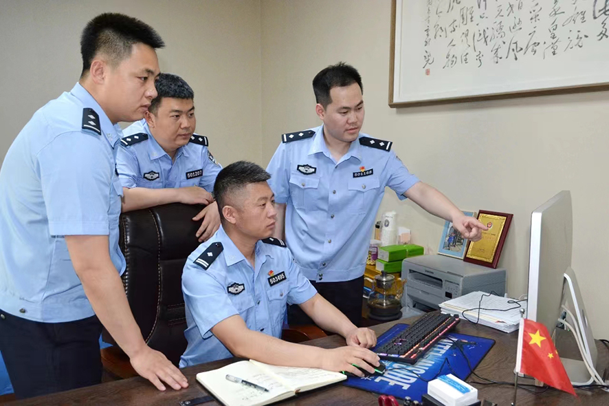 郑群(右二)正在和同事研究案件